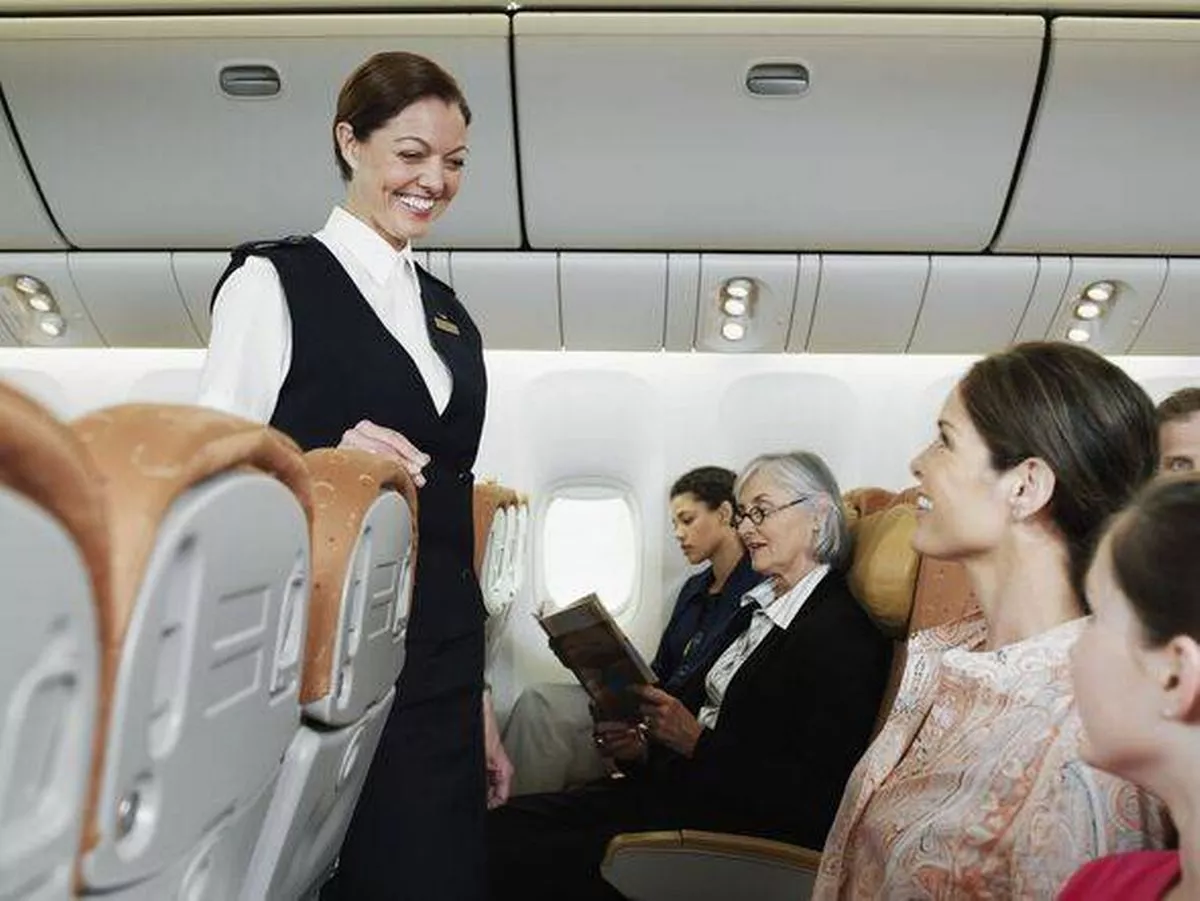 Flight attendant talking with passengers