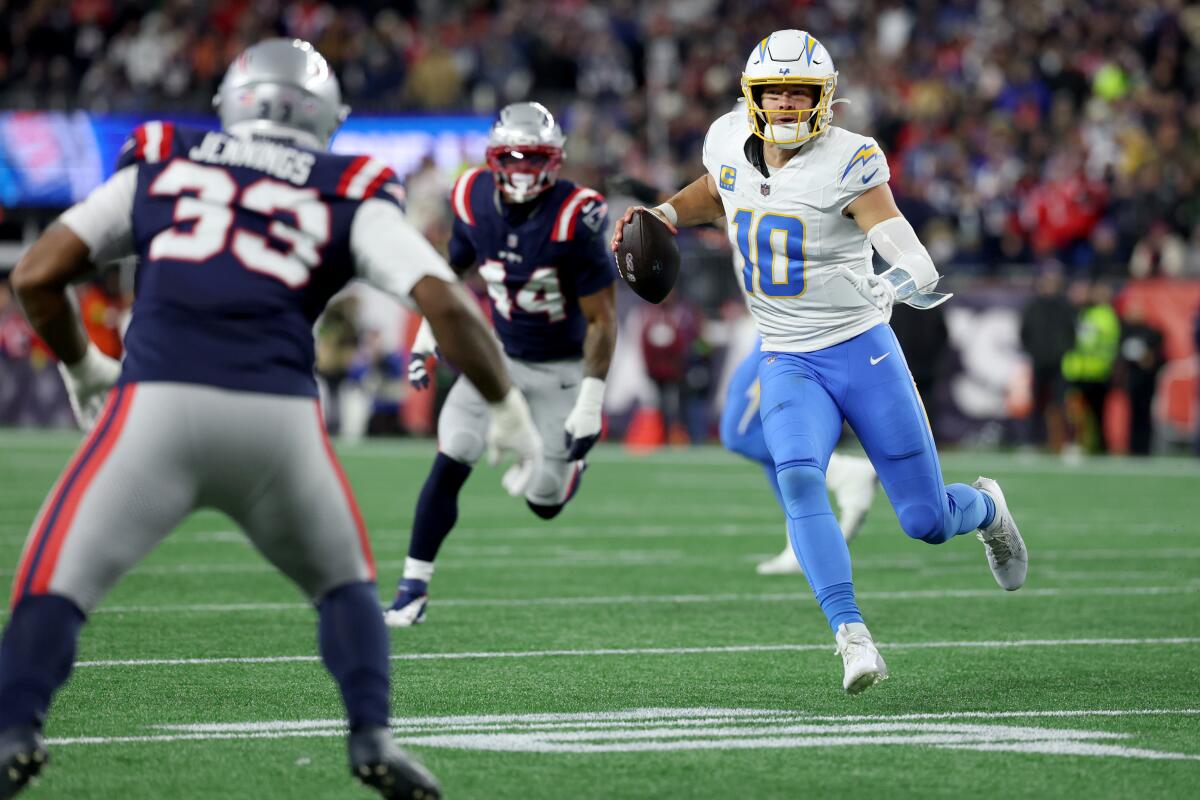 Chargers quarterback Justin Herbert scrambles against the New England Patriots in the AFC wild-card playoffs on Jan. 11.