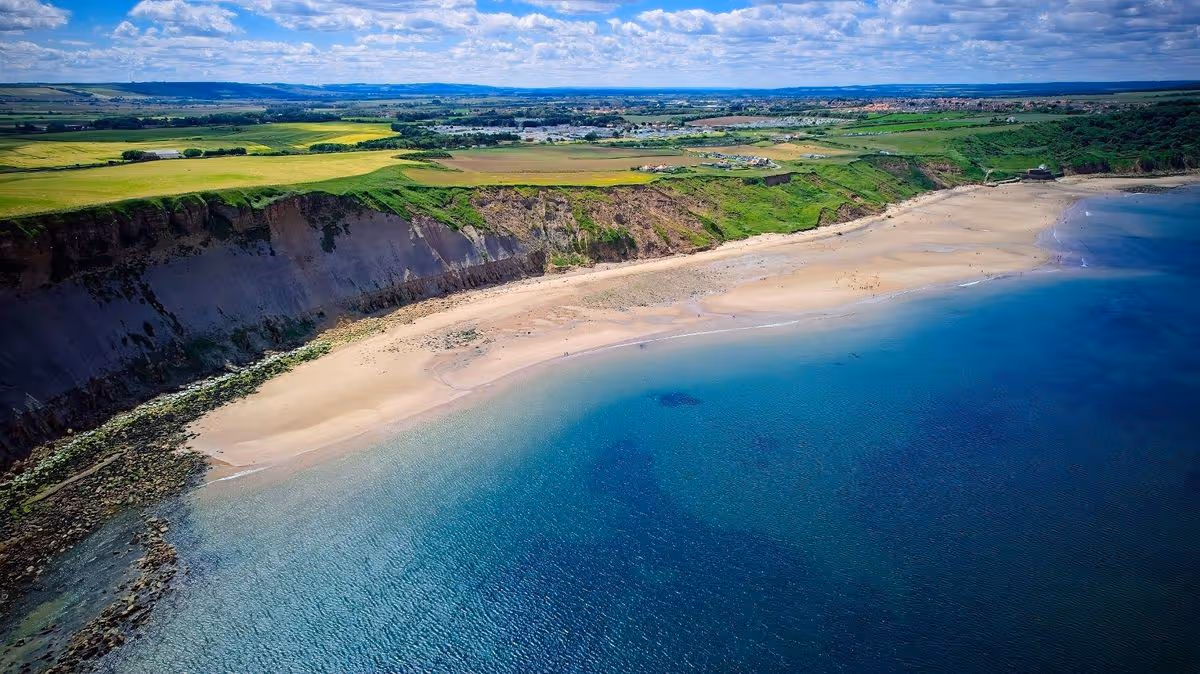 Aerial view of coastal landscape with beach and cliffs at Cayton Bay, Yorkshire