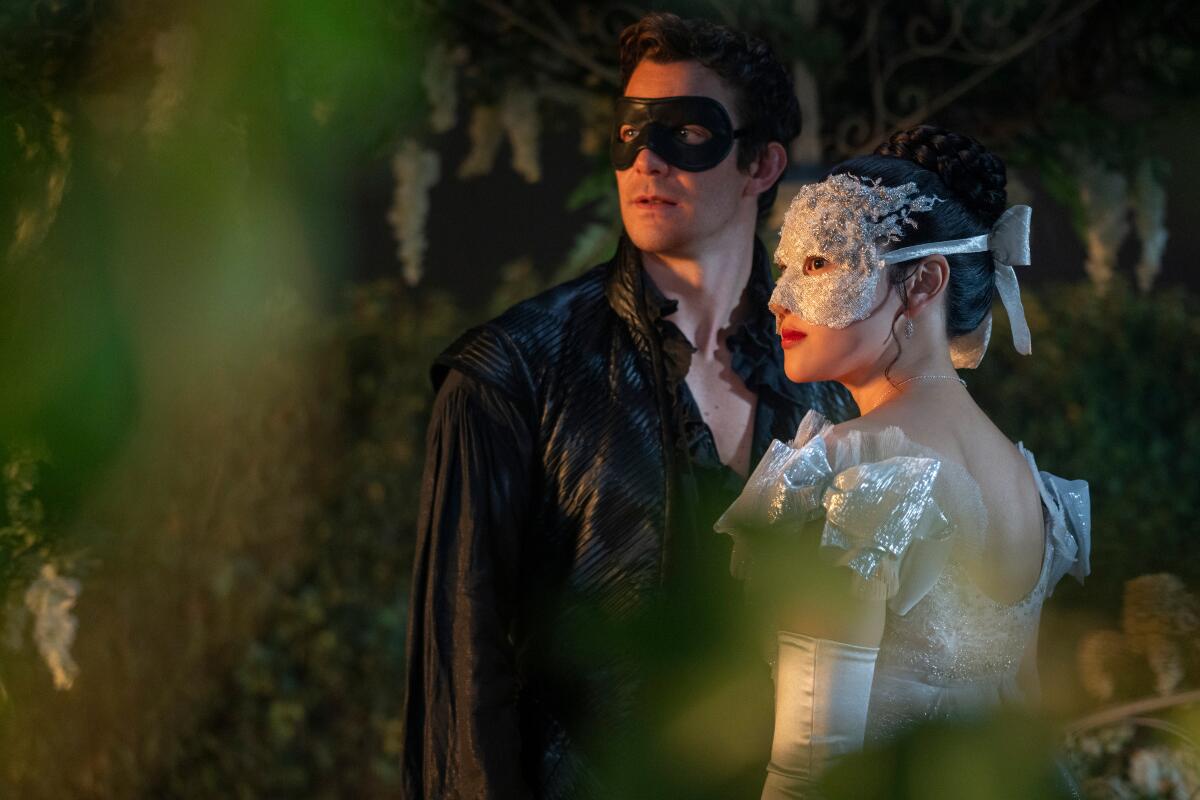 A man and woman wearing masked costumes