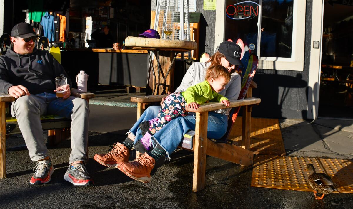 Natalie and Chris Garcia of Santa Barbara play with their daughter, Winnie, and a duck at June Lake Brewing.