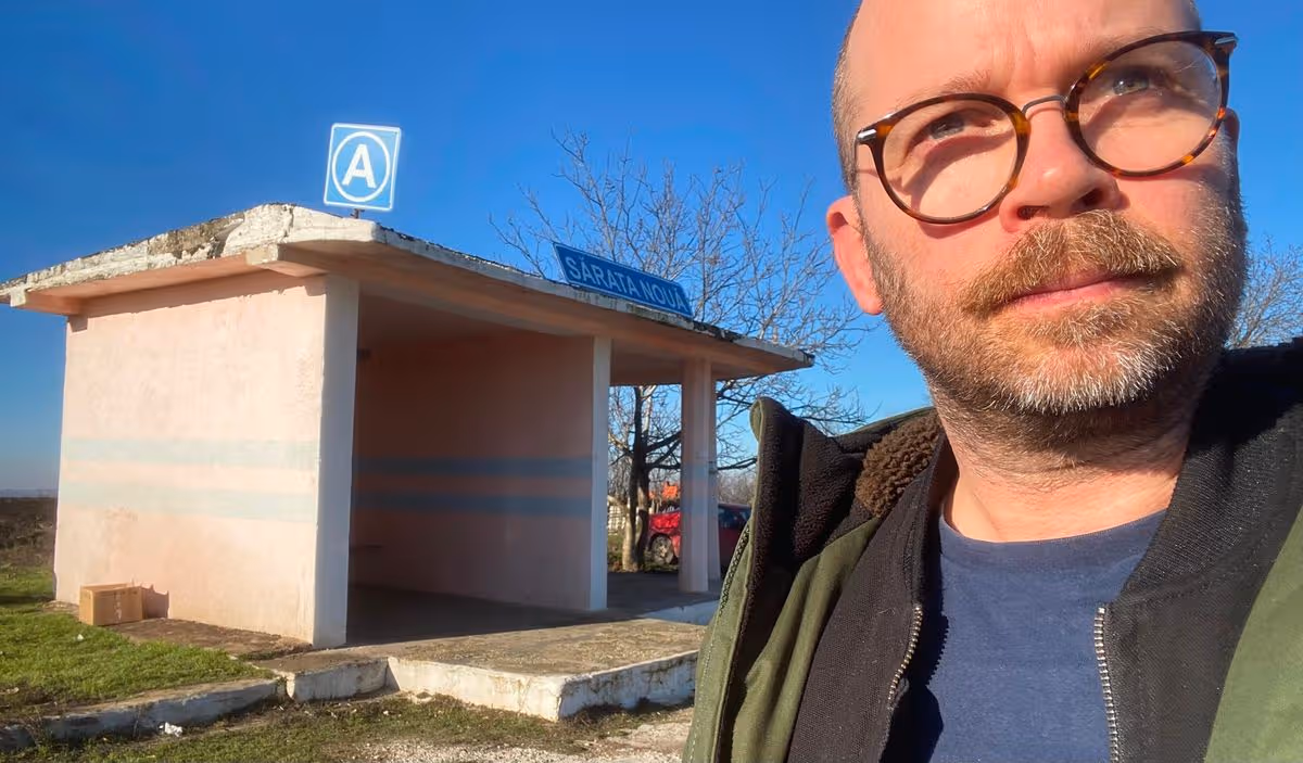 Jonathan in front of a bus stop