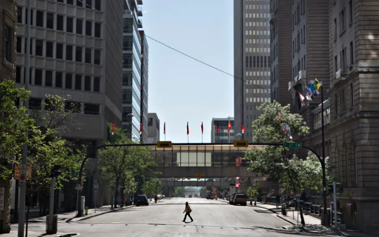 A woman crosses an empty downtown street in Calgary, Alberta
