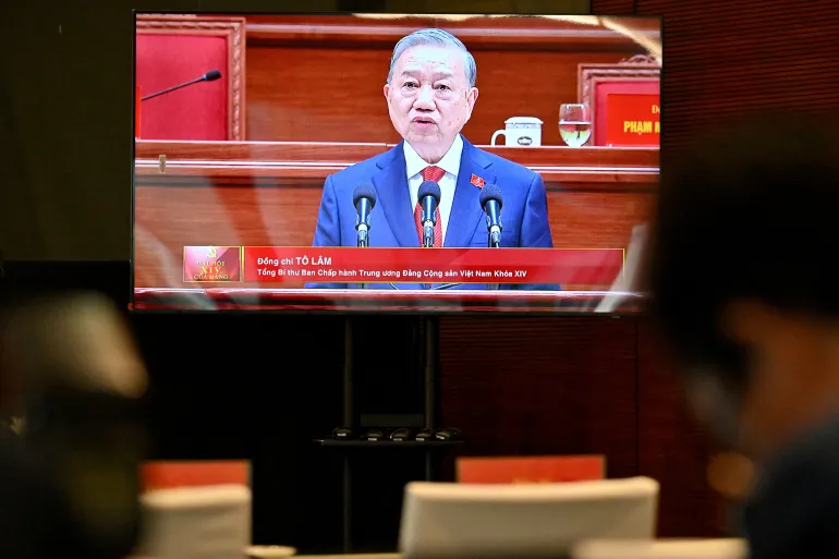 Vietnam's relected Communist Party General Secretary To Lam is seen on a screen as he speaks during the closing session of the Communist Party of Vietnam's (CPV) 14th National Congress at the National Convention Centre in Hanoi on January 23, 2026. Vietnam's Communist Party "unanimously" re-elected To Lam to the post of general secretary on January 23, it said on its website, confirming he will remain the country's top leader for the next five years. (Photo by Nhac NGUYEN / AFP