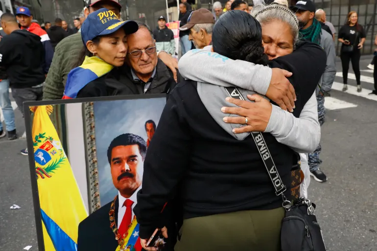 Supporters of Venezuelan President Nicolás Maduro embrace in downtown Caracas, Venezuela, Saturday, Jan. 3, 2026, after U.S. President Donald Trump announced that Maduro had been captured and flown out of the country. (AP Photo/Cristian Hernandez)