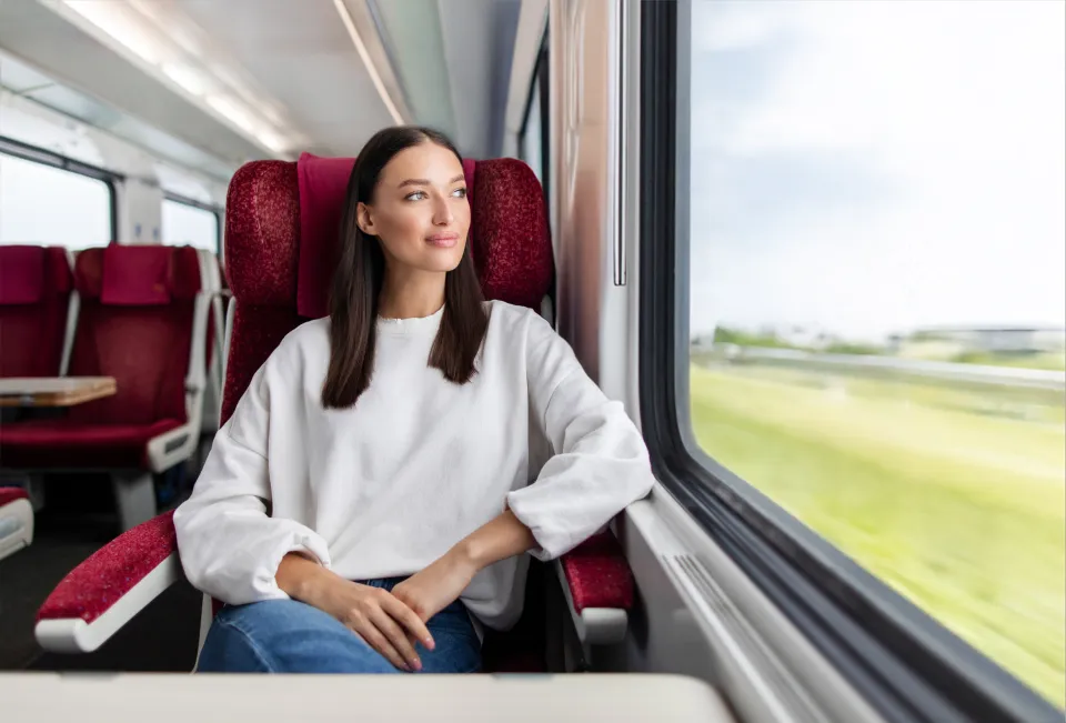 Pensive woman looking out the window of a train.