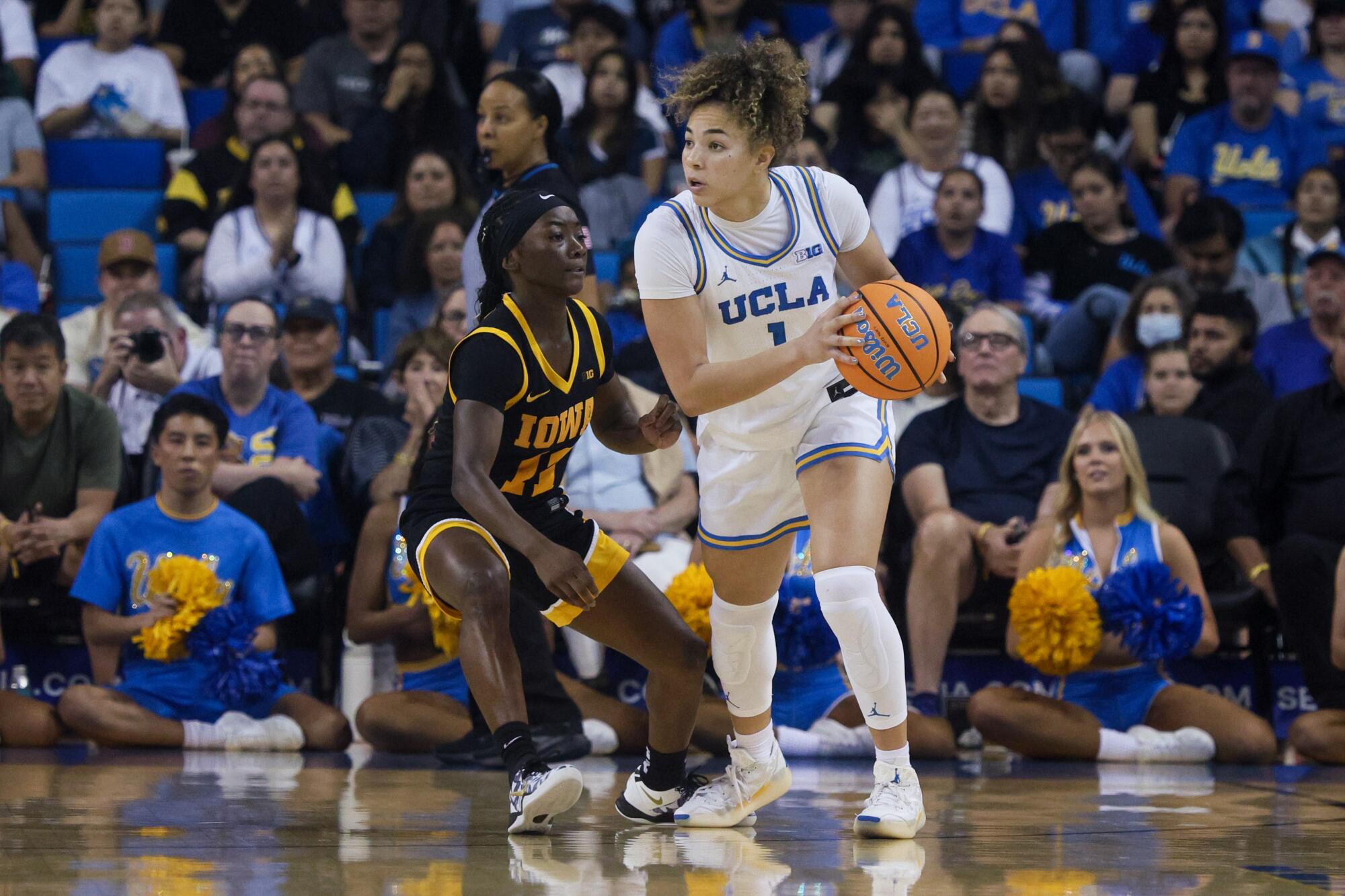 UCLA guard Kiki Rice, right, looks for a pass in front of Iowa guard Chit-Chat Wright during the first half Sunday.