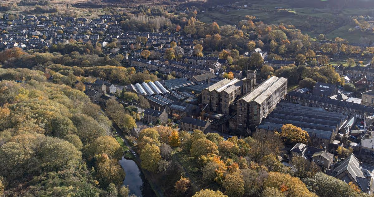An overhead view shows deciduous trees bearing autumnal colours surrounding "New Mills", a derelict former textile mill in the village of Marsden, near Huddersfield, in northern England on November 9, 2023. (Photo by Oli SCARFF / AFP) (Photo by OLI SCARFF/AFP via Getty Images)